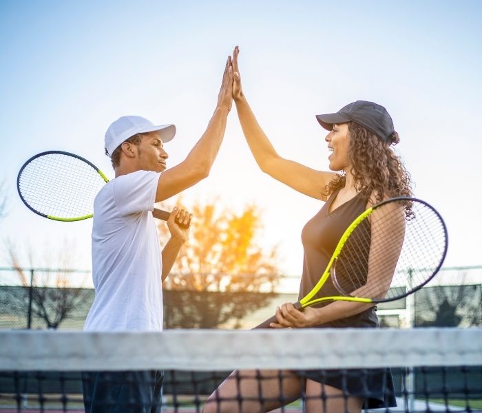Man and woman high-fiving after Tennis game